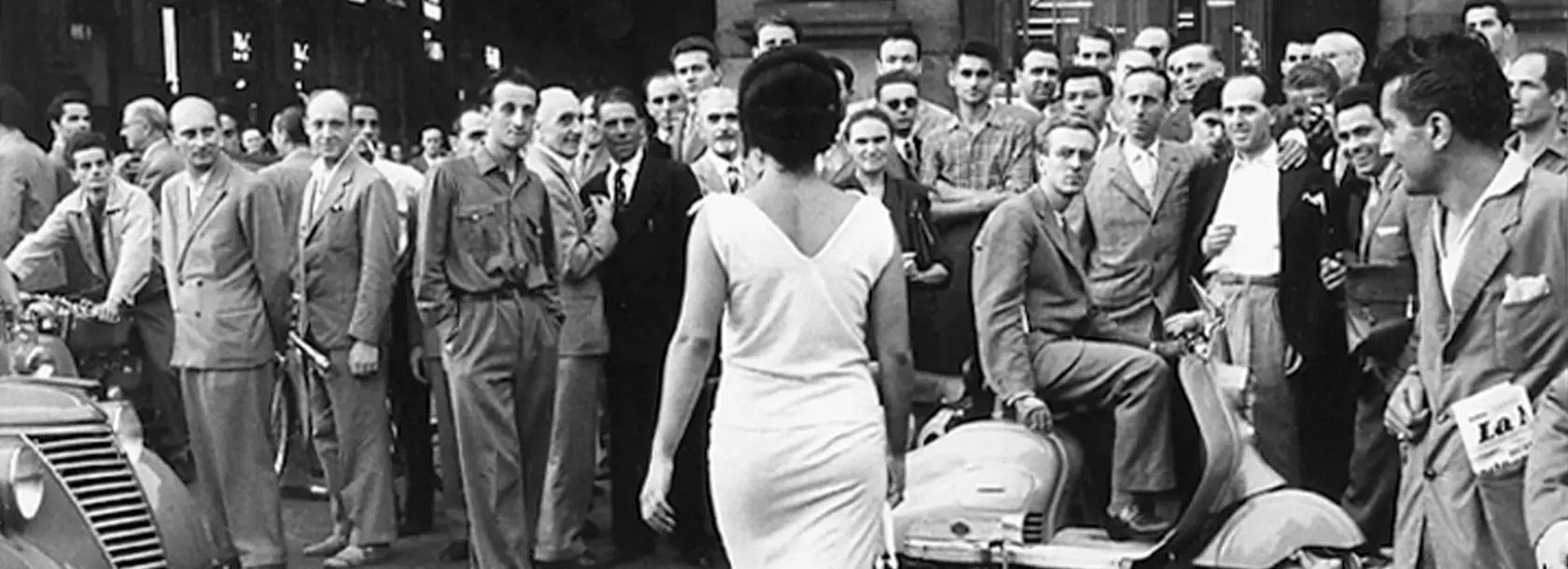 Fotografia in bianco e nero “Gli Italiani si voltano” che ritrae Moira Orfei mentre passeggia per Milano nel 1954, scattata da Mario De Biasi.